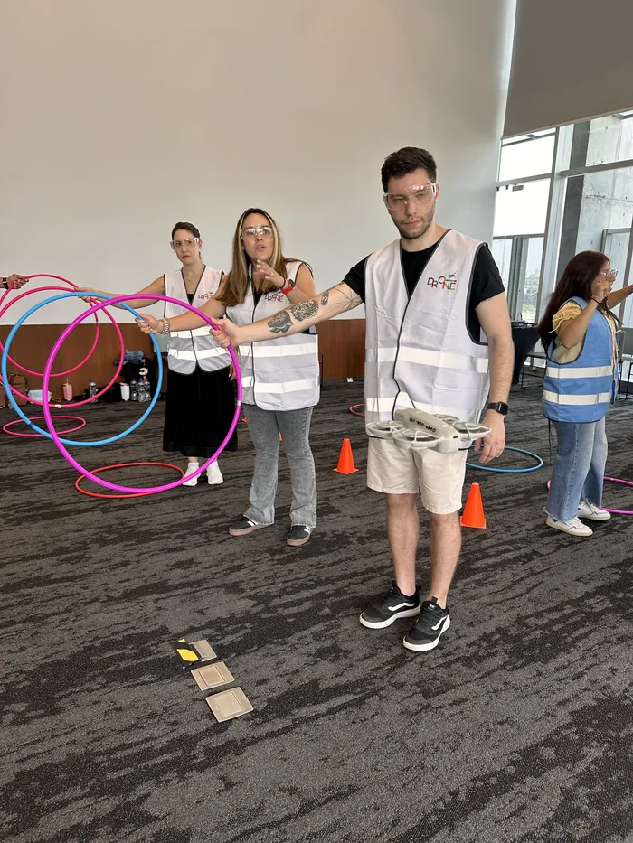 Participantes de Drone Control trabajando en equipo en salón